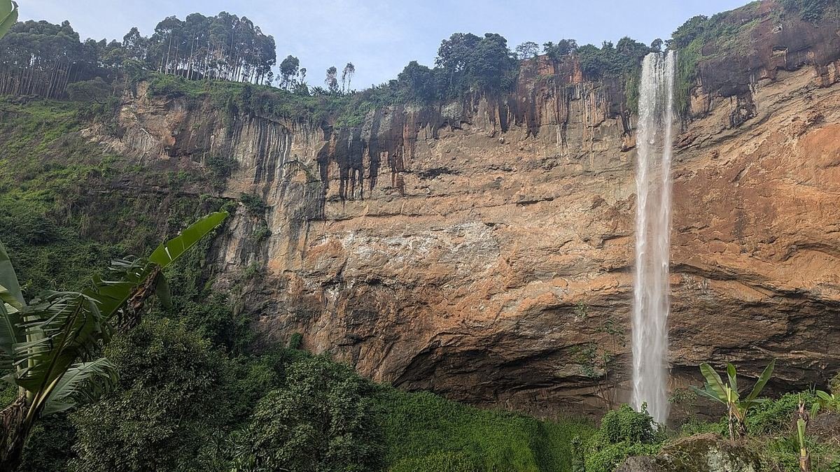 The main Sipi waterfall dropping down a tall orange cliff on the slopes of Mount Elgon
